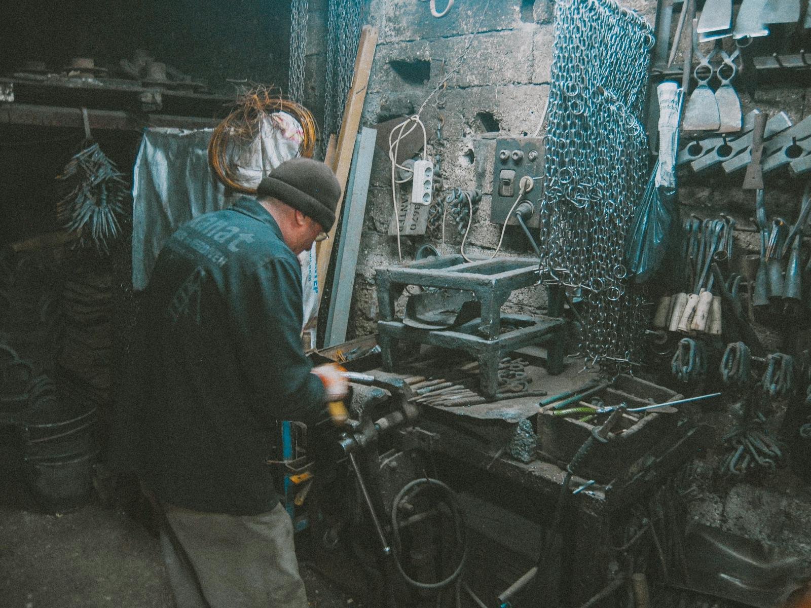 A documentary frame of a craftsman bending steel rebar in a sunlit workshop, sparks visible against the dark background.